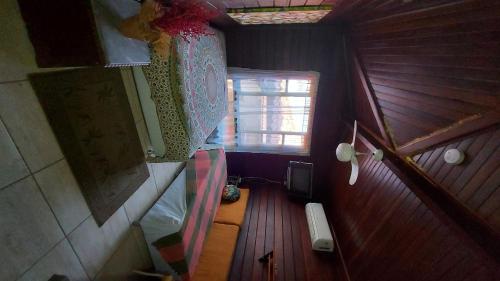 eine Draufsicht auf einen kleinen Dachbodenraum mit einem Fenster in der Unterkunft Eco Paradise Muriqui in Mangaratiba