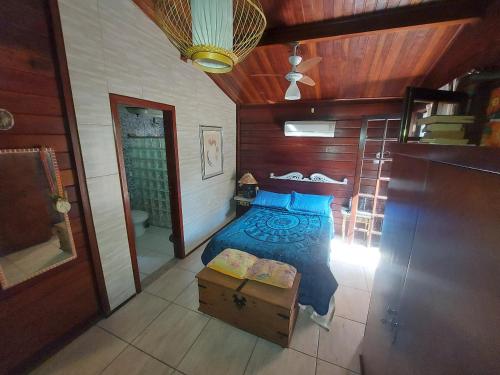 a bedroom with a bed with blue pillows at Eco Paradise Muriqui in Mangaratiba