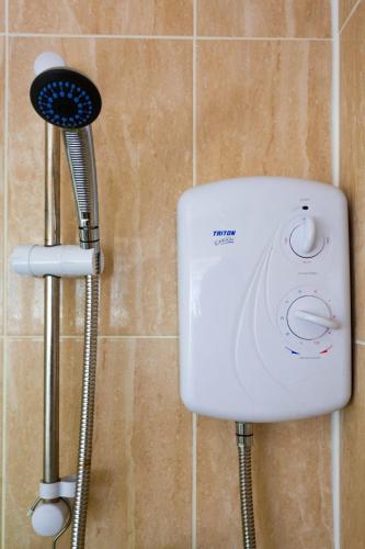 a shower head and a hair dryer in a bathroom at Private room in Birmingham city centre with free parking in Birmingham