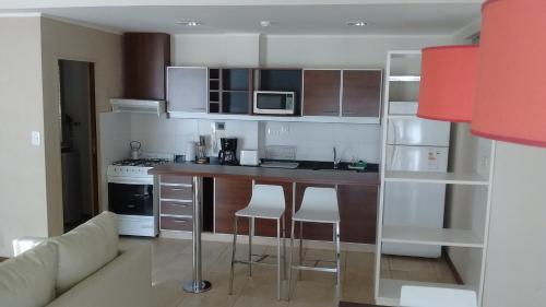 a kitchen with a counter and chairs in a room at 11 Peyret Rent Aparts in Colón