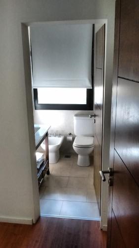 a bathroom with a toilet and a sink at 11 Peyret Rent Aparts in Colón
