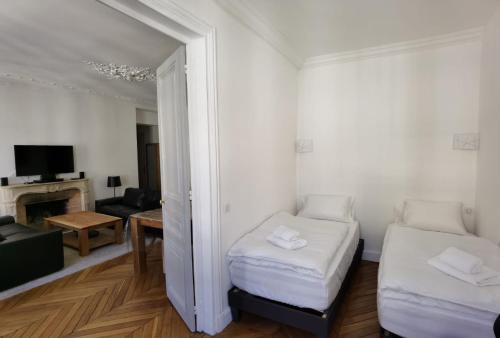 een kamer met 2 bedden en een woonkamer bij 3 PIECES 4****, AU COEUR DU QUARTIER HISTORIQUE in Versailles