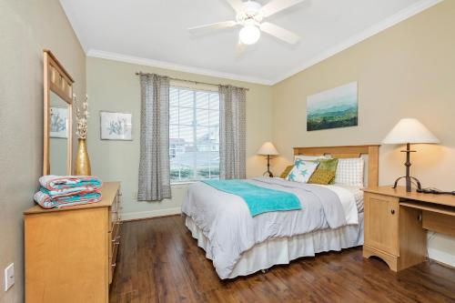 Schlafzimmer mit einem Bett, einem Schreibtisch und einem Fenster in der Unterkunft The Dawn Oceanfront Condo on Seawall Blvd in Galveston