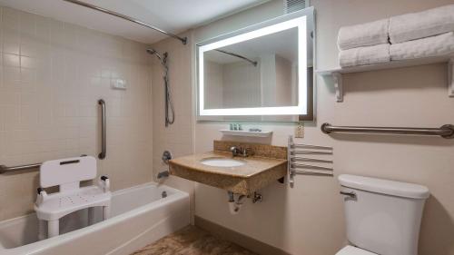 a bathroom with a sink and a tub and a toilet at Best Western Historic Area in Williamsburg