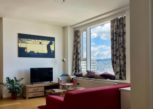 a living room with a red couch and a large window at Downtown View in Bratislava