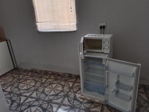 a microwave oven sitting on top of a refrigerator at Fourties Guest House in Phalaborwa
