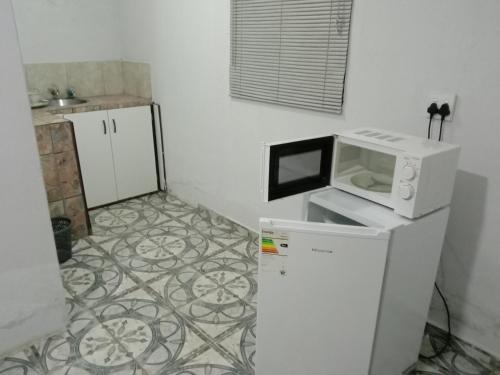 a microwave on top of a refrigerator in a kitchen at Fourties Guest House in Phalaborwa