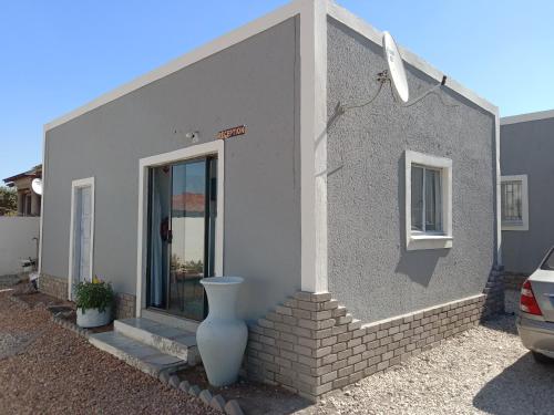 a small house with a vase on the side of it at Fourties Guest House in Phalaborwa