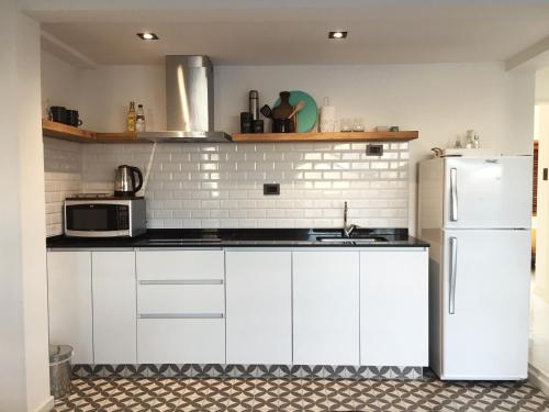 a kitchen with white cabinets and a white refrigerator at Moderno departamento en San Pedro in San Pedro