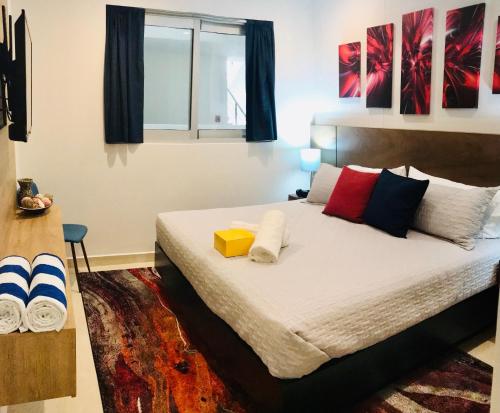a bedroom with a large bed with colorful pillows at Camino Al Mar with Amazing View of the Ocean, Beach and Pool in Mazatlán