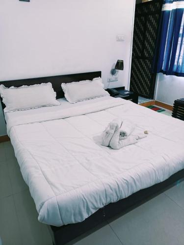 a large white bed with a stuffed animal on it at The Royal Lake View Villa in Udaipur