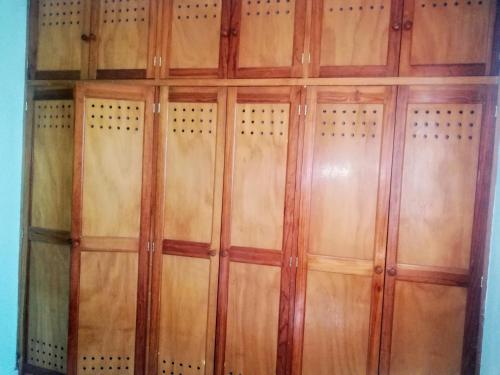 een houten kast met houten deuren in een kamer bij Style House in Cancun in Cancun