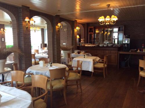 une salle à manger avec des tables et des chaises ainsi qu'un bar dans l'établissement Hotel de Admiraal, à Noordwijk aan Zee