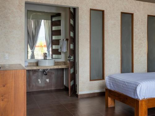 a bedroom with a bed and a sink and a mirror at Hotel Santa Rosa in Valle de Bravo