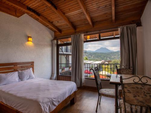 a bedroom with a bed and a window with a view at Hotel Santa Rosa in Valle de Bravo
