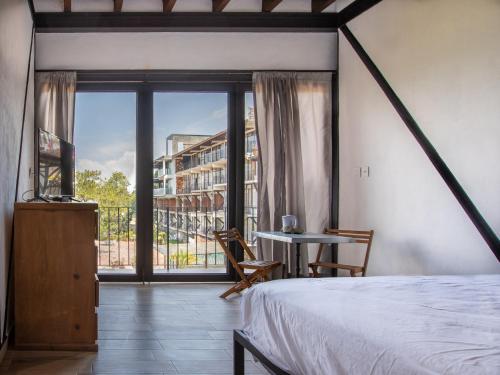 a bedroom with a bed and a large window at Hotel Santa Rosa in Valle de Bravo