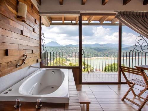 a bath tub in a room with a large window at Hotel Santa Rosa in Valle de Bravo