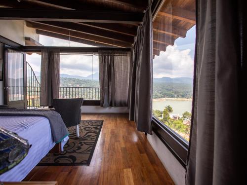 a bedroom with a bed and a large window at Hotel Santa Rosa in Valle de Bravo