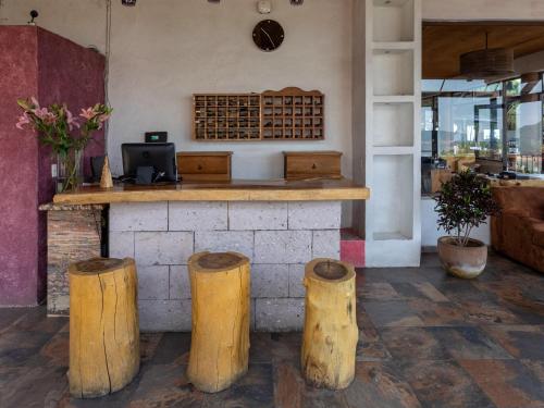 a restaurant with a counter with three wooden stumps at Hotel Santa Rosa in Valle de Bravo