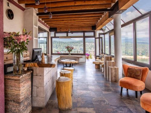 um restaurante com mesas, cadeiras e janelas em Hotel Santa Rosa em Valle de Bravo
