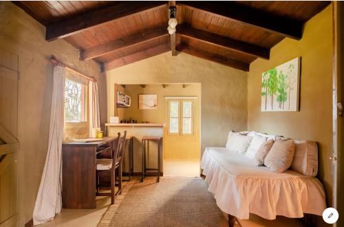 a bedroom with a bed and a desk and a kitchen at Ranchito Macondo in San Antonio de Areco