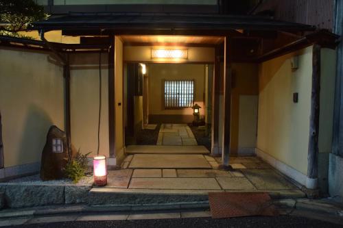 an entrance to a building at night with a candle at Kyoto Ryokan SAKANOUE in Kyoto