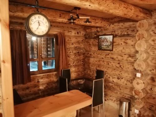 Habitación con pared de madera y reloj en la pared. en Brvnare filip, en Nova Varoš