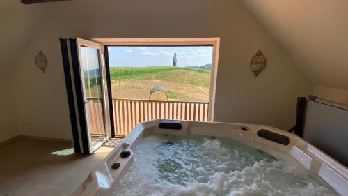 a large bath tub in a room with a window at Landvilla Sinelia premium in Dietersdorf am Gnasbach