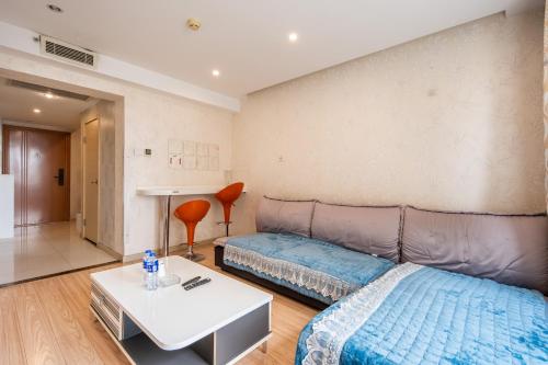 a living room with a bed and a table at Tianjin Mengxiangjia Loft Hotel Apartment in Tianjin
