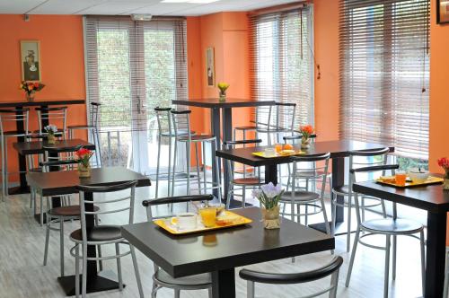una sala da pranzo con tavoli, sedie e pareti arancioni di Mister Bed Lomme a Lomme