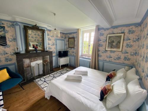 um quarto com uma grande cama branca e papel de parede azul em Château d'Aigneville em Aigneville