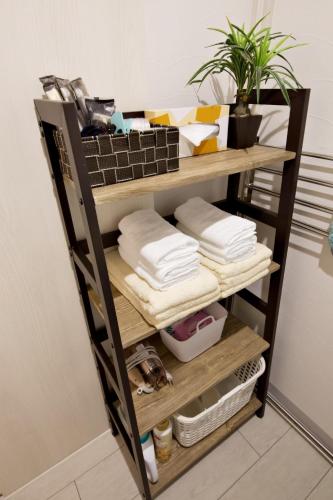 a shelf with towels and towels on it at K-HOUSE Naha Maejima in Naha