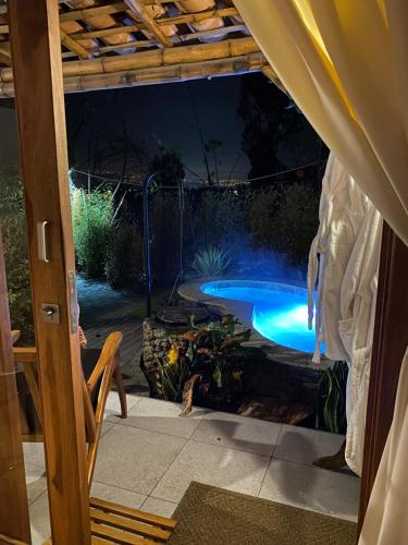 a backyard with a swimming pool at night at Hostería Colibri Aeropuerto in Tababela