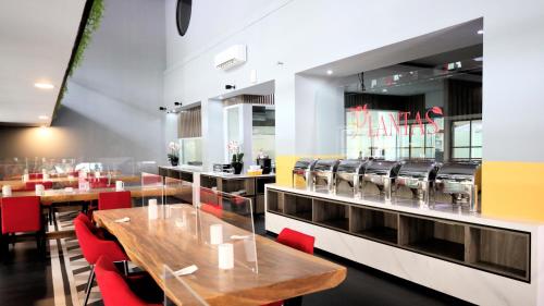 een restaurant met houten tafels en rode stoelen bij Moritz Hotel RSAB Harapan Kita in Jakarta