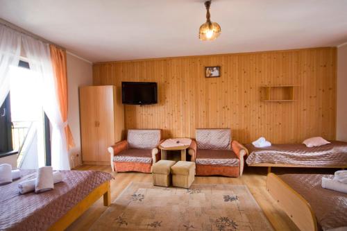 a living room with two beds and a tv at Pokoje Janka Gliczarów Górny in Gliczarów
