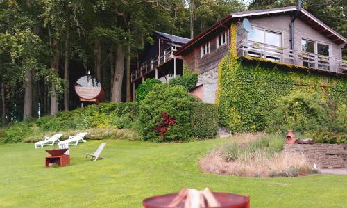 a house with a yard with chairs and a building at Chalet de la Sablière in Amougies