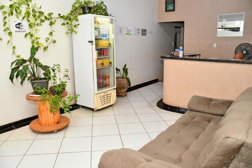 a living room with a couch and a refrigerator at Hotel Alphard in Várzea Grande