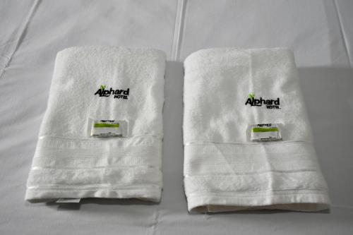 dos toallas sentadas encima de una cama en Hotel Alphard, en Várzea Grande