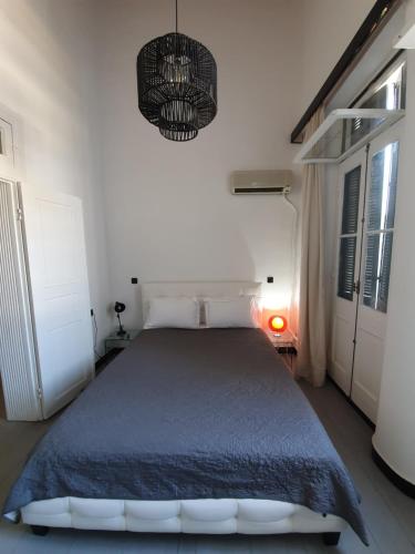 sypialnia z łóżkiem i żyrandolem w obiekcie The Pitoulis Mansion w mieście Igoumenitsa