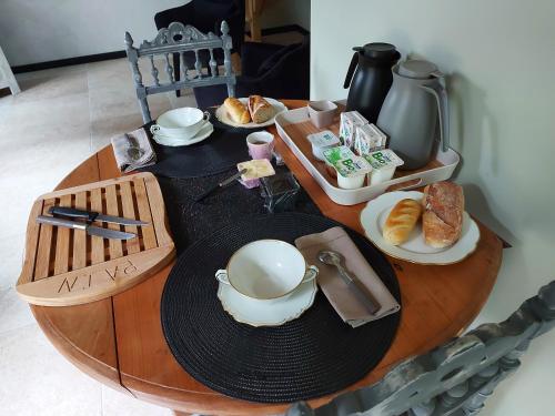 een tafel met een beker en borden eten erop bij LA PETITE CHARMILLE in Châteauponsac