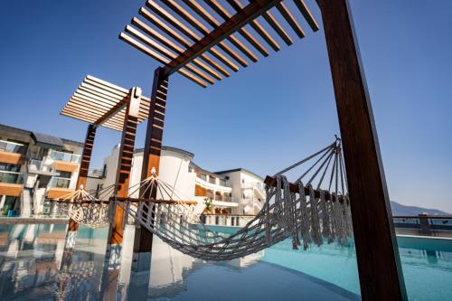 a hammock on the side of a swimming pool at Liberty Fabay - Ultra All Inclusive in Fethiye