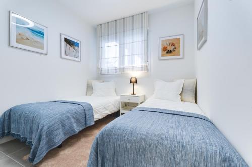 two beds in a room with white walls at Casa Tumry in Denia