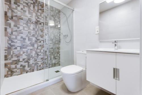 a white bathroom with a shower and a toilet at Casa Tumry in Denia