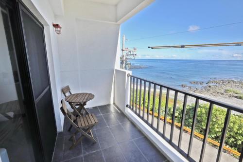 a balcony with a chair and a view of the ocean at OceanSeeker in Green Island