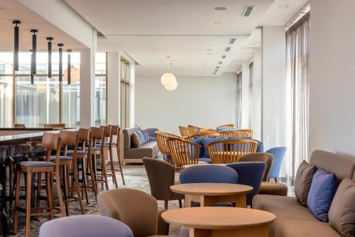 a waiting room with chairs and tables and a bar at Radisson Blu Resort Al Hoceima in Al Hoceïma