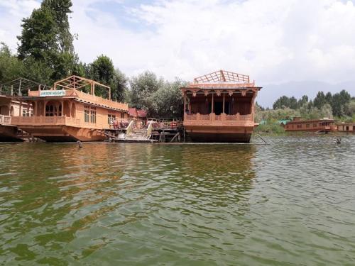 two boats are docked in the water at Houseboats Jackson Heights in Srinagar
