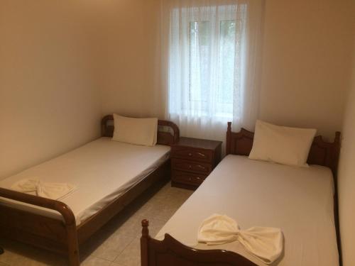 2 łóżka pojedyncze w pokoju z oknem w obiekcie Guesthouse "Athina" w mieście Ellinikón