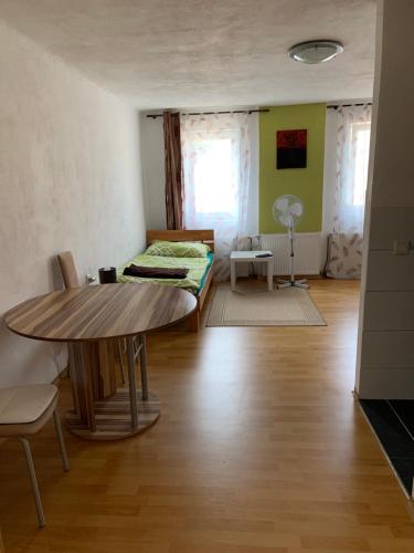 a living room with a table and a bed at Privat Zimmer KF in Knittelfeld
