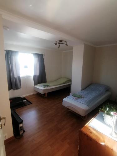 a small room with two beds and a window at Seaview apartment Karmøy in Sæveland