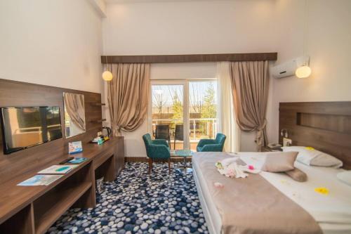 a hotel room with a large bed and a desk at Sandikli Thermal Park Hotel in Sandıklı